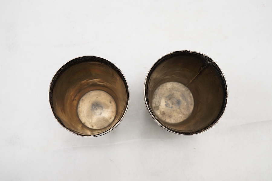 A pair of 19th century white metal mounted horn beakers, with oval appliqués engraved with a sheep and initial, makers mark only IP, one lacking base mount, height 12.5cm.